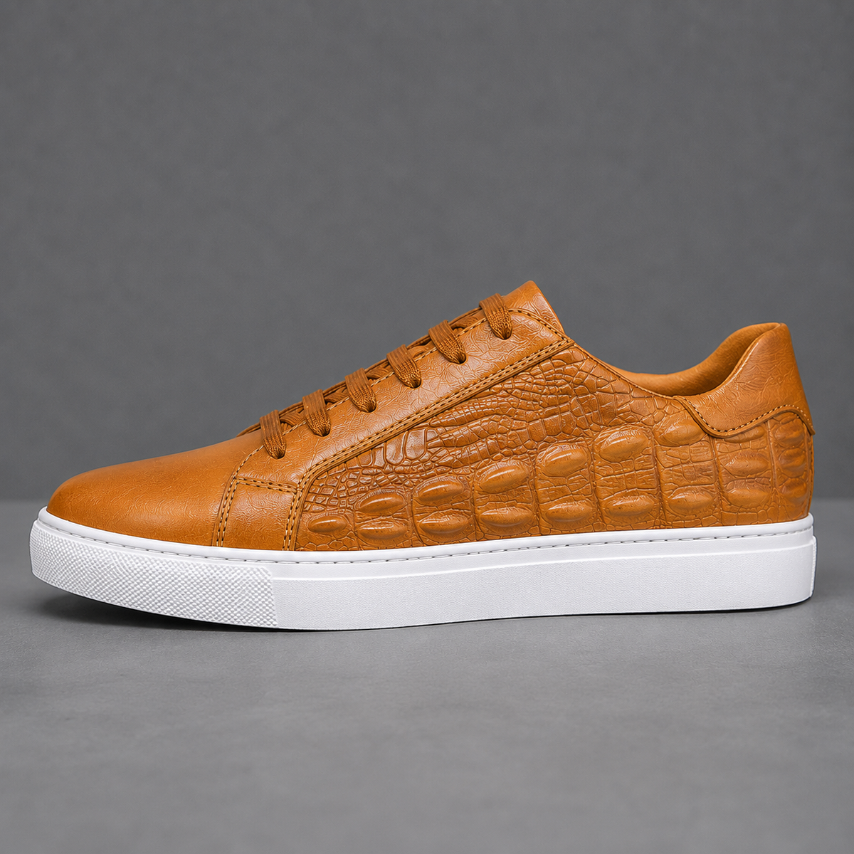 Angled view of leather court sneakers with crocodile texture