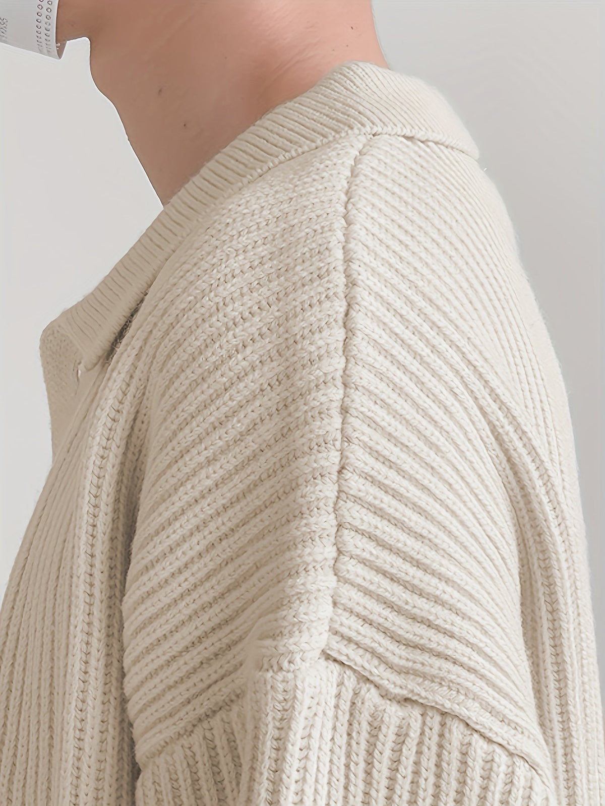 Cardigan displayed with its collar, buttons, and ribbed texture