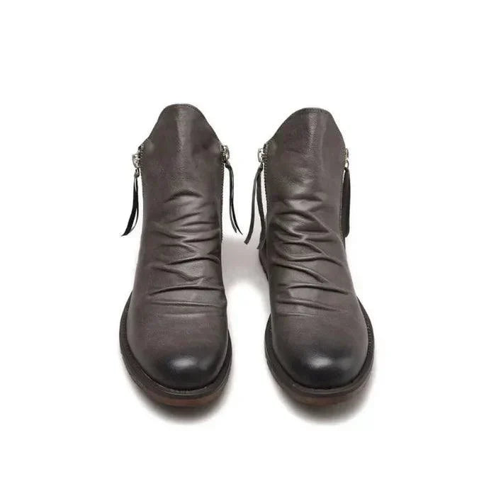 Men's leather boots shown at an angle with detailed stitching and solid soles