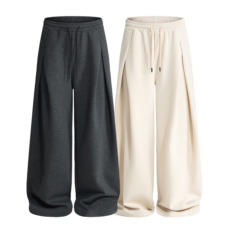 Waistband and relaxed fit of pleated baggy sweatpants shown in detail