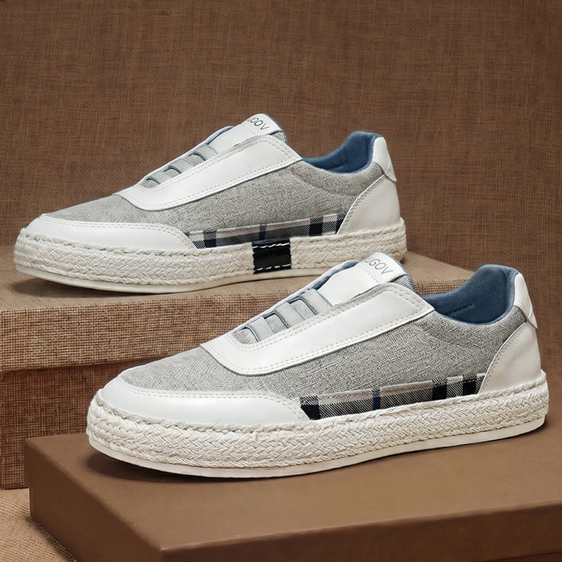 Pair of woven linen sneakers with leather detailing on a clean background