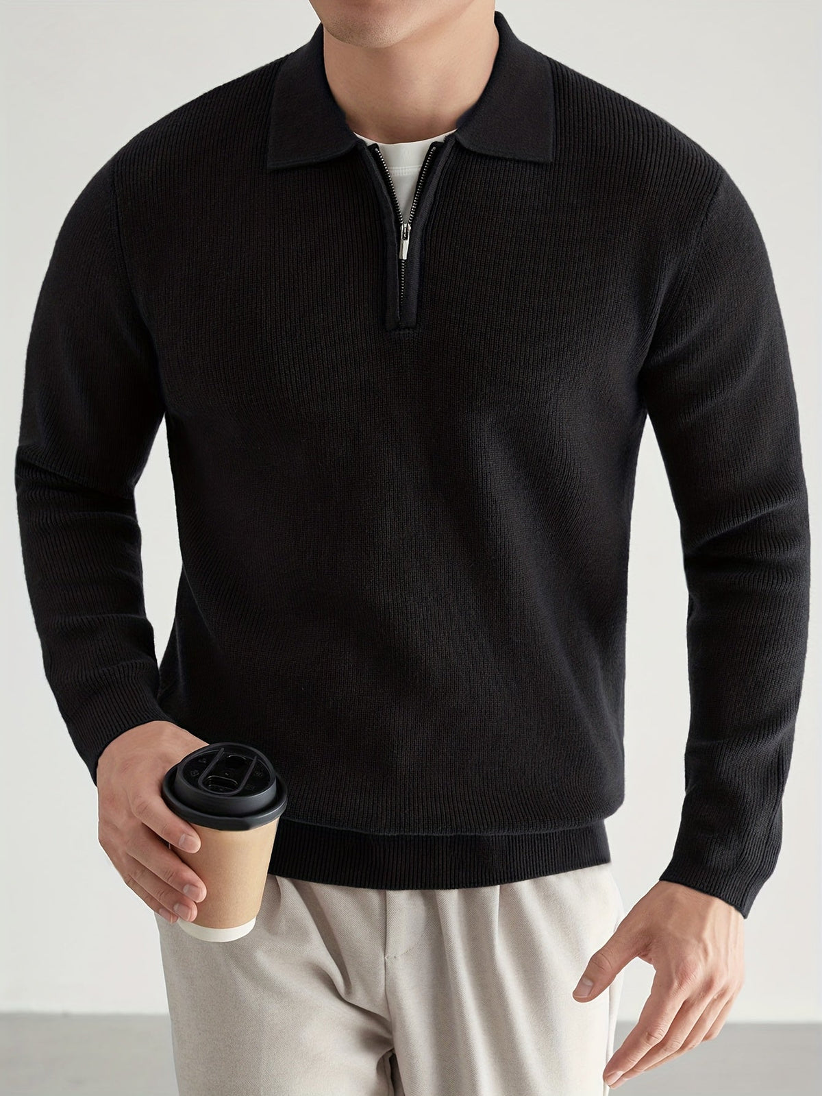 Close-up of the quarter-zip fastening on a knit polo sweater