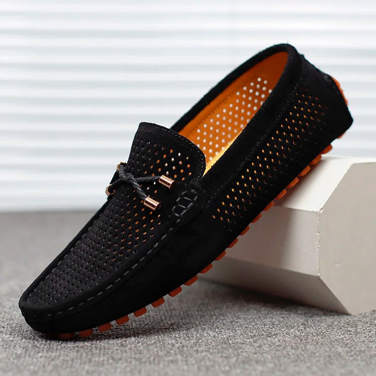 Side profile of a men's suede loafer with a flexible driving sole
