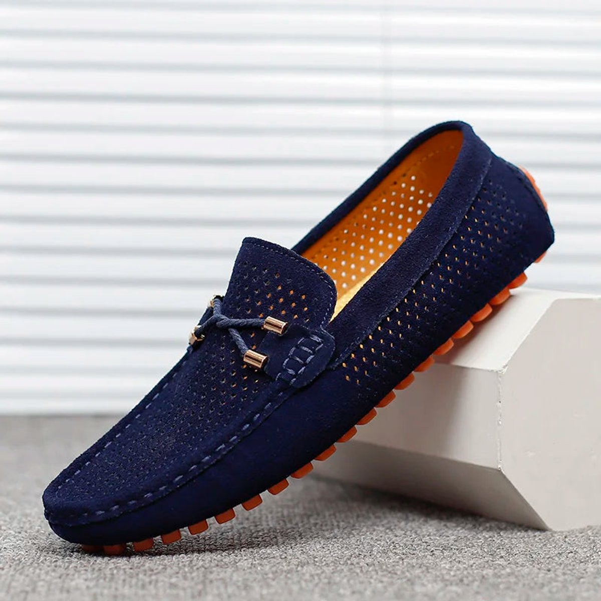 Pair of perforated suede loafers displayed with both shoes visible