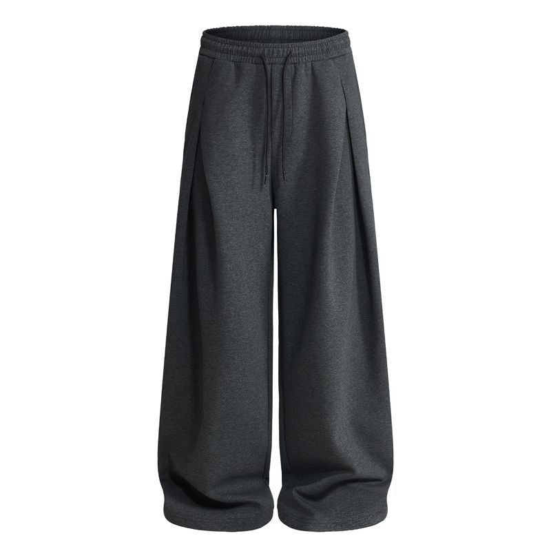 Pleated baggy sweatpants displayed from the side with roomy legs