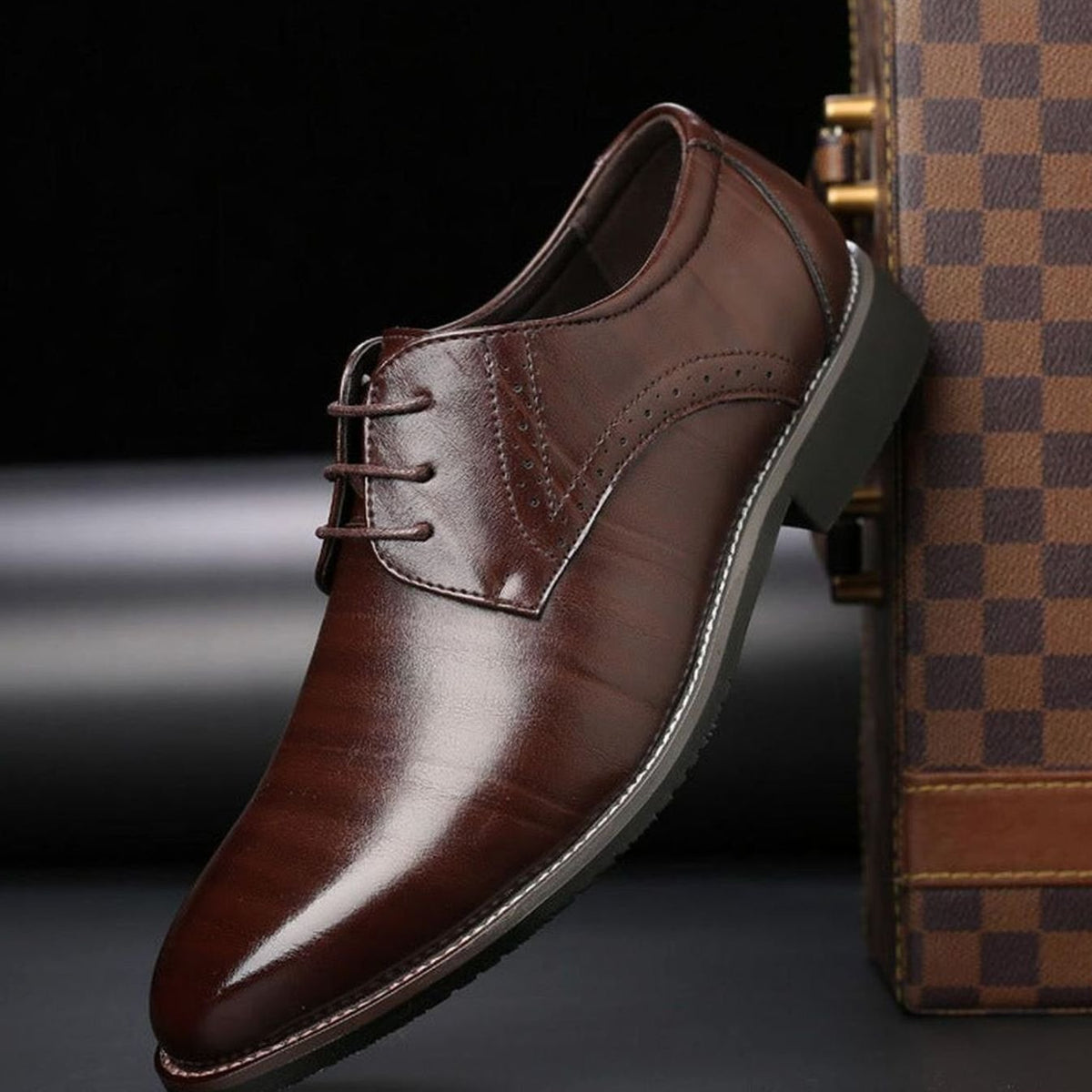 Men's polished leather brogue dress shoes shown from the side with classic perforated detailing